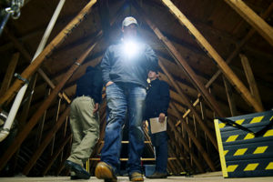 Brett Miller of Romex Pest Control searches a dim attic for signs of rodent pests at Texas Rodent Academy, Texas A&M AgriLife Research and Extension Center at Dallas (Texas A&M AgriLife photo by Gabe Saldana)